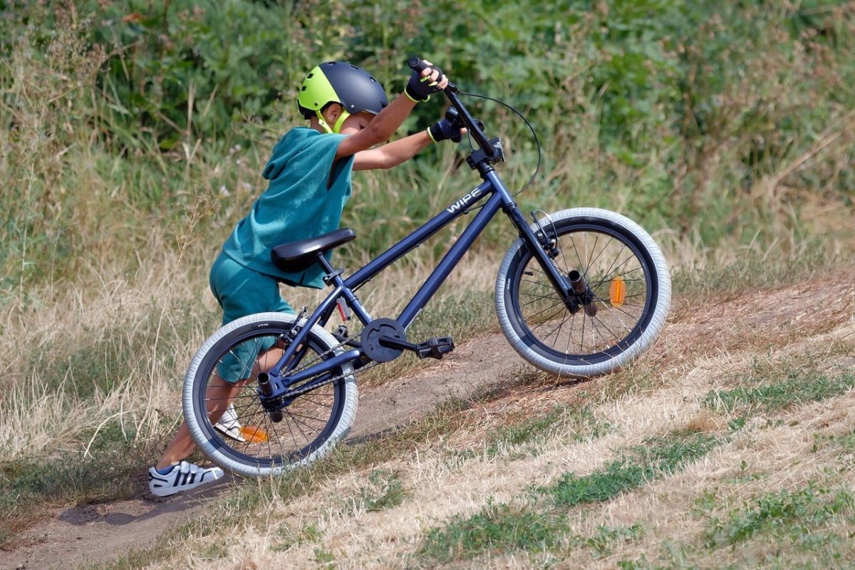 child, bicycle, helmet, green, grass, outdoor, child pushing bicycle, active, adventure, childhood, boy, safety, summer, exercise, effort, active child, youth, sports activities, blue bicycle, outdoor adventure, carefree