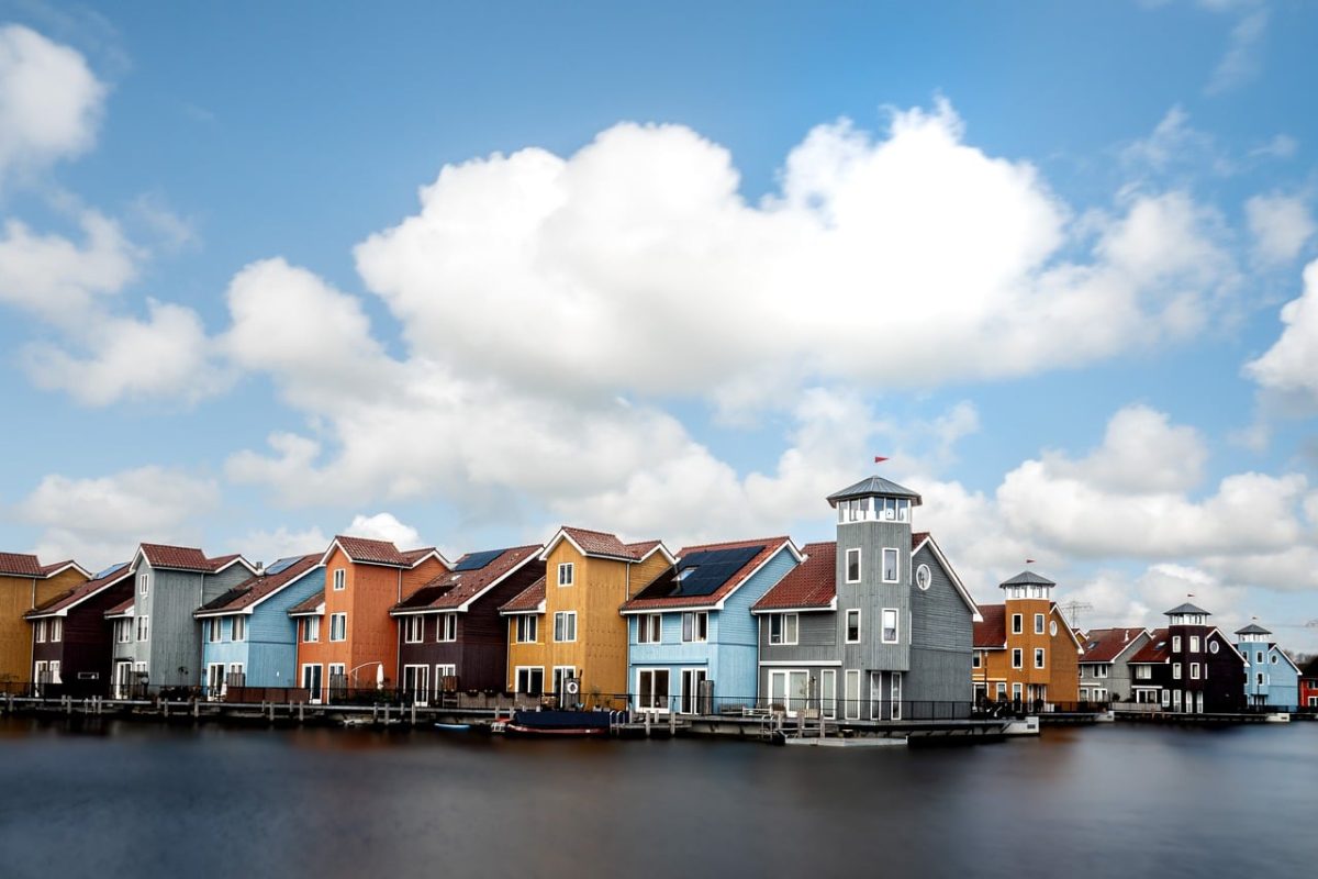 colorful houses, by the water, blue sky, netherlands, flowing water, residential buildings, calm environment, recreation, houses by the canal, architecture, modern design, drinkable water, fresh air, natural beauty, urban landscape, horizon, reflection, autumn day, calm waters, exterior, walk by the water