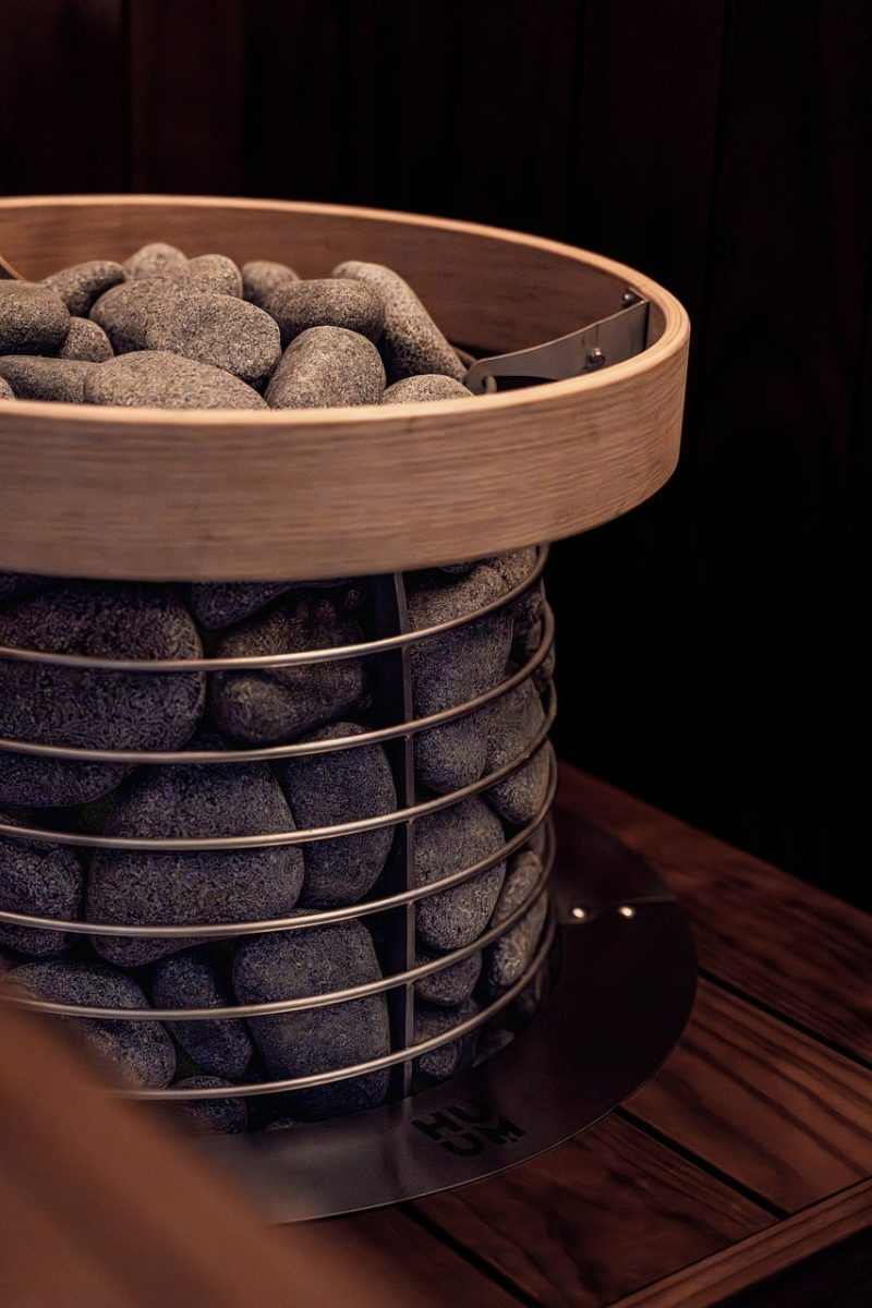 sauna, sauna heater, electric heater, modern sauna, black wood, nordic design, sauna inspiration, dark wood, sauna stones, led lights, nordic architecture, sauna bench, brown wood, black wall, sauna lights, aesthetic, sauna interior, wood, aesthetic sauna