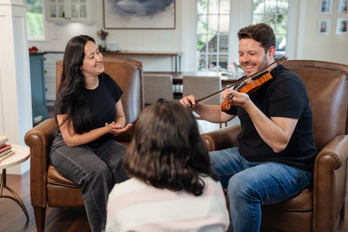 music, violin, home, family, comfort, happy, friendship, sitting, laughing, black t-shirt, weekday, privacy, hobby, entertainment, sofa, indoor, casual, relaxation, interactive, social