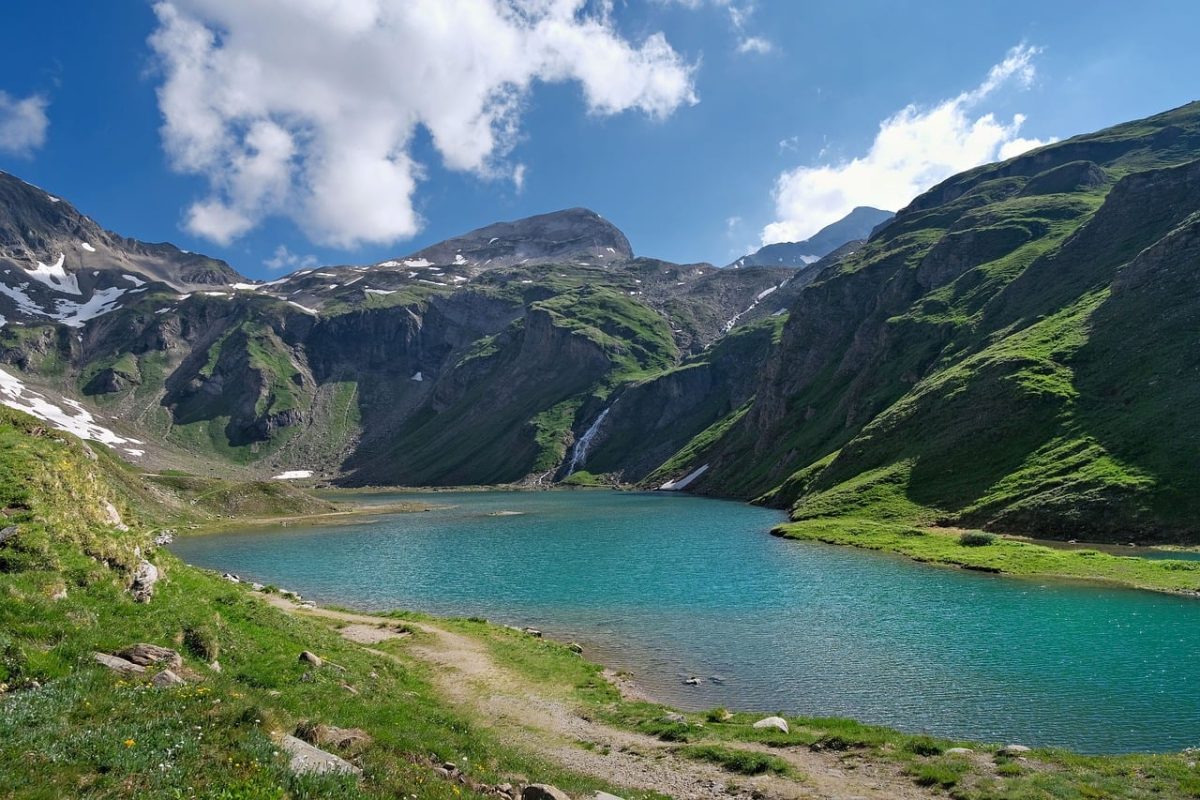 lake, mountain, valley, mountain landscape, blue sky, sunny day, green grass, snow-capped mountains, hiking, natural beauty, peaceful environment, tourist destination, clear water, summer day, panoramic view, nature, calm, tourist area, clean air, retreat