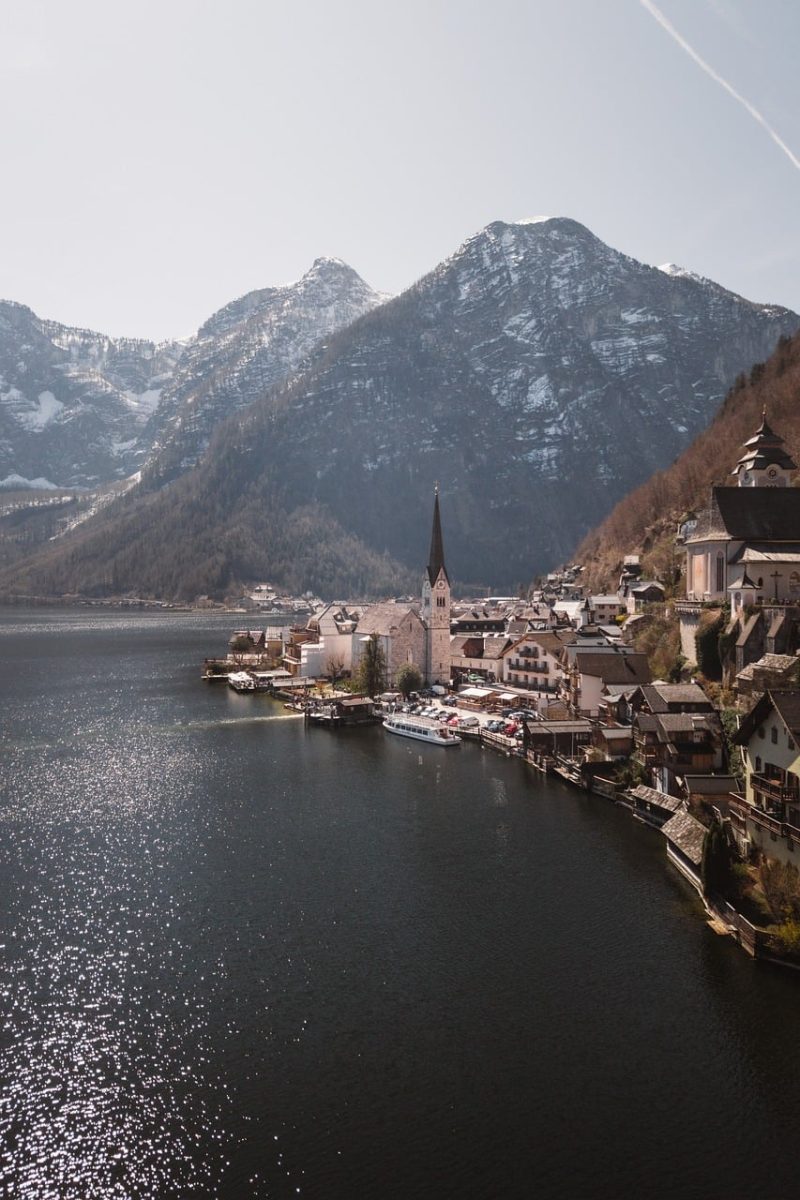 hallstatt, lake, mountain scenery, church tower, calm water, nature, alpine mountains, daylight, reflection, mountain view, peaceful scenery, lake and mountains, front view, cultural town, postcard, calm day, village atmosphere, architectural landmarks, blue sky, tourist destination