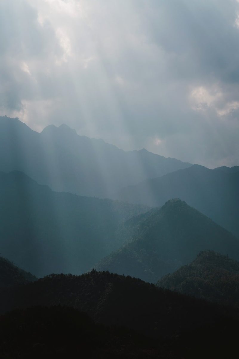 misty mountains, sunbeams, mountain landscape, layered ridges, dramatic clouds, atmospheric light, early morning, silhouette forest, soft haze, serene nature