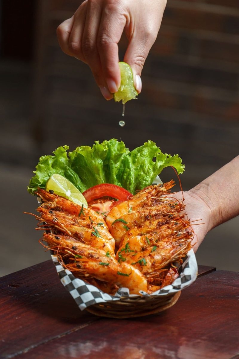 seafood, shrimp, lime, hand, lime juice, grilled shrimp, salad, basket, dinner, fresh, served, decorative leaf, paprika, decoration, wooden table, culinary, food design, tomato slice, grated cheese, food