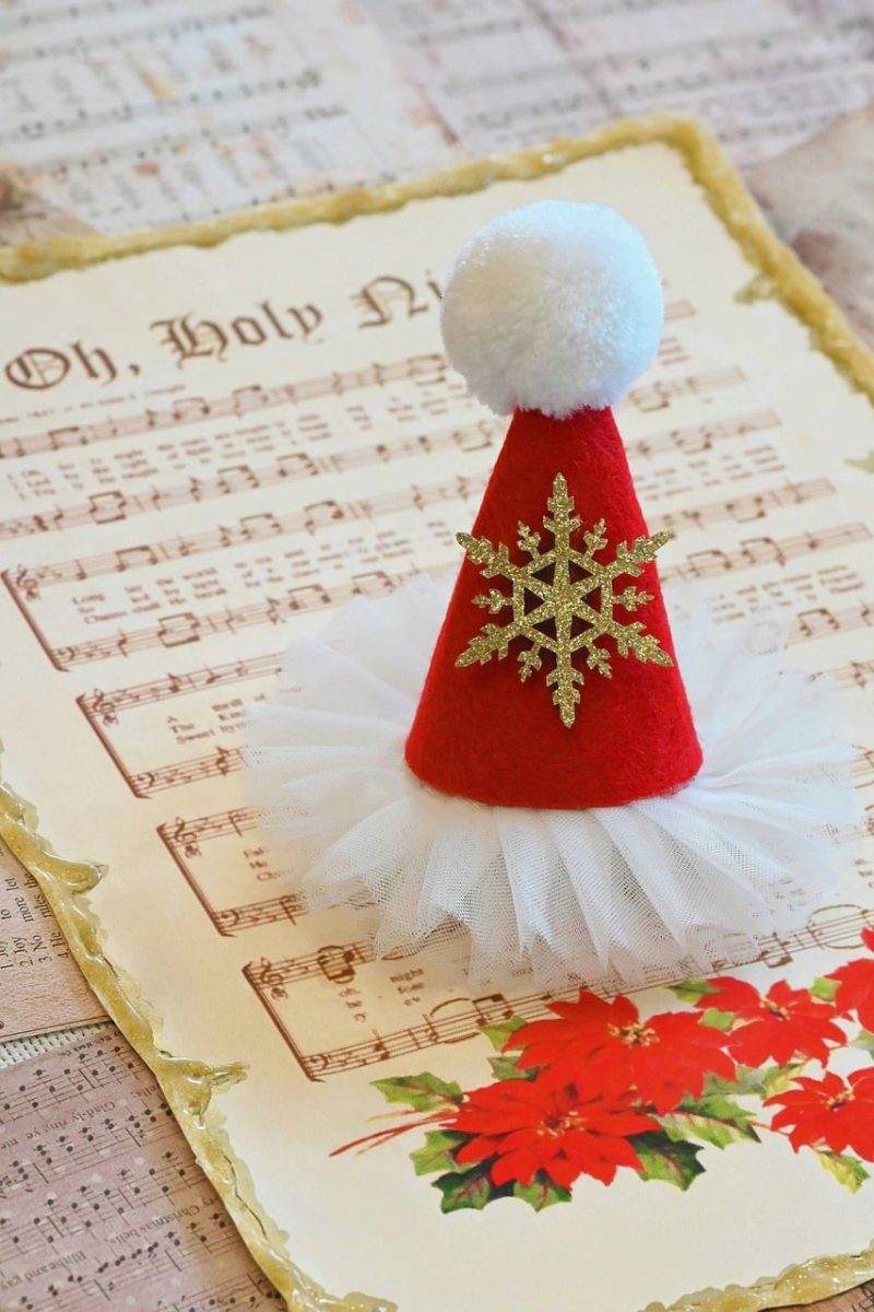 christmas decoration, santa hat, holiday hat, christmas craft, festive ornament, christmas music, sheet music, oh holy night, christmas card, poinsettia, holiday background, winter decoration, handmade ornament, red and white hat, christmas snowflake, glitter snowflake, felt hat, christmas tulle, festive scene, holiday still life, christmas tradition, seasonal decor, cute christmas, cozy holiday, christmas aesthetic