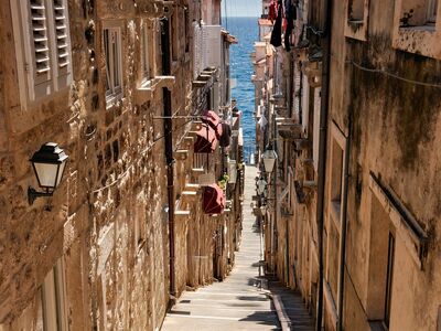 europe, tourism, italy, city, history, architecture, sea, summer, beach, old street, fortress, steps, street lamps, shade, balcony, blue sky, destination, walk, masonry, tourist attraction