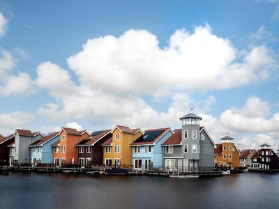 colorful houses, by the water, blue sky, netherlands, flowing water, residential buildings, calm environment, recreation, houses by the canal, architecture, modern design, drinkable water, fresh air, natural beauty, urban landscape, horizon, reflection, autumn day, calm waters, exterior, walk by the water