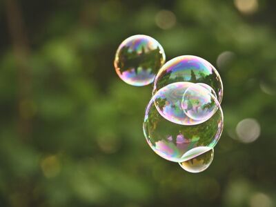 soap bubbles, summer day, green background, outdoor activities, colorful, magical atmosphere, crystal balls, blur effect, children's entertainment, light reflections, natural light, transparency, abundance, playful mood, photographic art, macro photography, bubble magic, children's games