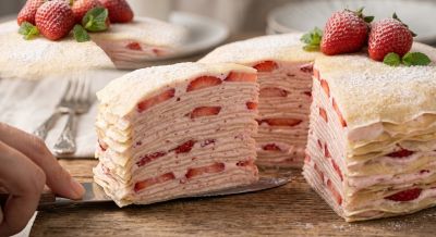 mille crepe cake, strawberry cake, layered cake, cake slice, fresh strawberries, dessert, pastry cream, sweet treat, mint leaves, elegant dessert, powdered sugar, cake server, wooden table, afternoon tea, baking art, cake presentation, delicate pastry, cake cross section, cake serving, kitchen