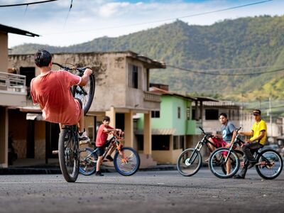 cyclist, bicycle, trick, nature, town, youth, mountains, skill, leisure, summer, friendship, fun, urban scene, wheelie, adrenaline, team sport, community, balance, creativity, local, young