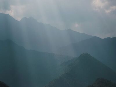 misty mountains, sunbeams, mountain landscape, layered ridges, dramatic clouds, atmospheric light, early morning, silhouette forest, soft haze, serene nature
