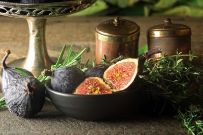 figs, ceramic bowl, fresh herbs, wooden surface, figs on table, still life, luxury vase, metal salt shakers, plant decoration, autumn atmosphere, cultural motifs, luxury food, green color, rustic style, vintage decor, traditional motif, kitchen utensils, luxury kitchen