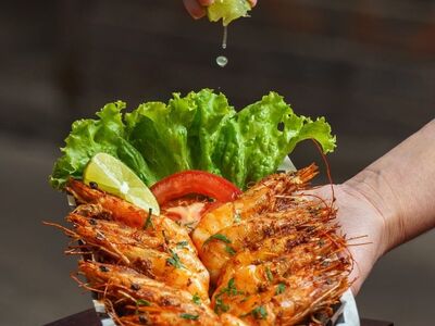 seafood, shrimp, lime, hand, lime juice, grilled shrimp, salad, basket, dinner, fresh, served, decorative leaf, paprika, decoration, wooden table, culinary, food design, tomato slice, grated cheese, food
