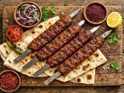 adana kebab, turkish food, minced lamb, grilled meat, skewer, flatbread, sumac, onion, grilled tomato, lemon, chili, protein, nutritious meal, nutritional value, spicy, wooden board, gastronomy, traditional cuisine, rustic, food styling