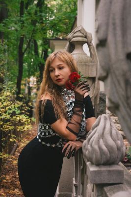woman, red roses, mesh glove, autumn, fashion, nature, statue, black dress, foliage, long hair, ornamental fence, art, stone, outdoor, jewelry, elegance, black and white fashion, green background, trees, evening gown