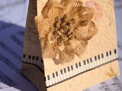handmade card, gift bag, paper craft, floral decoration, jute flower, rustic design, piano keys, music notes, sheet music, artistic background, vintage style, decorative paper, creative craft, eco friendly design, musical theme, handmade gift, textured paper, floral ornament, arts and crafts, creative background, paper art, diy decoration, craft project, music and art, rustic charm