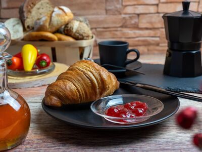 breakfast, croissant, jam, honey, coffee machine, coffee pot, black dishes, bread basket, bun, paprika, tomatoes, rustic table, baked goods, morning meal, mediterranean, comfortable, food scene, enjoyment, café atmosphere