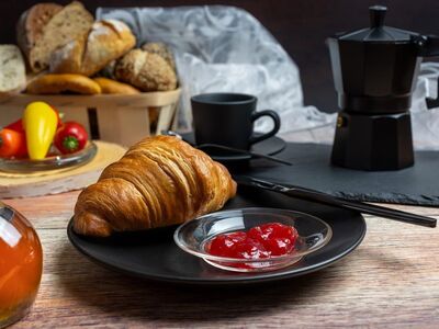 breakfast, croissant, jam, honey, coffee machine, coffee pot, black dishes, bread basket, bun, paprika, tomatoes, rustic table, baked goods, morning meal, mediterranean, comfortable, food scene, enjoyment, café atmosphere