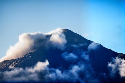 mountain, nature, landscape, volcano, smoke, clouds, summit, blue sky, daytime, majestic, winter, geology, natural force, dramatic, scenery, awe-inspiring, pristine, lonely, rawness