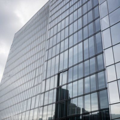 window cleaning, modern architecture, glass building, skyscraper construction, building maintenance, high-rise worker, urban landscape, building facade, urban climbing, safety equipment, rope work, cleanliness, workwear, weather conditions, outdoor work, access systems, tall buildings, architectural design, office building, blue glass