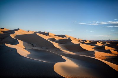 desert, sand dunes, light blue sky, desert landscape, light reflections, shadows, sand waves, natural landscape, no people, silence, desolate area, loneliness, nature, aridity, horizon, lonely landscape, summer day, peaceful atmosphere, golden tones, warmth