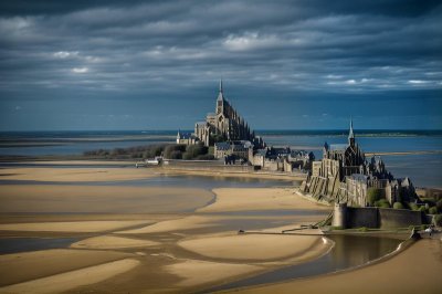 mont saint-michel, normandy, historic architecture, abbey, island community, medieval fortress, unesco world heritage, sheep, meadow, natural landscape, tower, abbey on a hill, landscape with streams, tourist attraction, church architecture, famous landmark, mediterranean climate, vineyard, culture