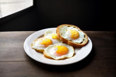fried eggs, sunny side up, breakfast, toast, buttered toast, fried bread, yolk, white plate, white porcelain, slate table, blue background, studio lighting, delicious, meal, food, morning, gourmet, culinary, appetizing, simple