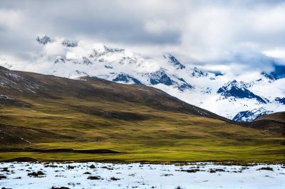 snow-capped mountains, alpine pasture, grass hills, high-altitude plateau, turquoise lakeshore, plateau wilderness, cloudy sky, tibetan landscape, azure lake, carolingian area